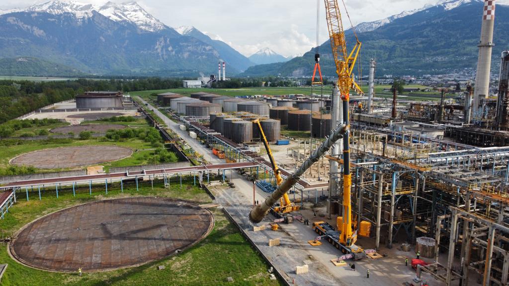 Lattice crane lifting a process column at a refinery