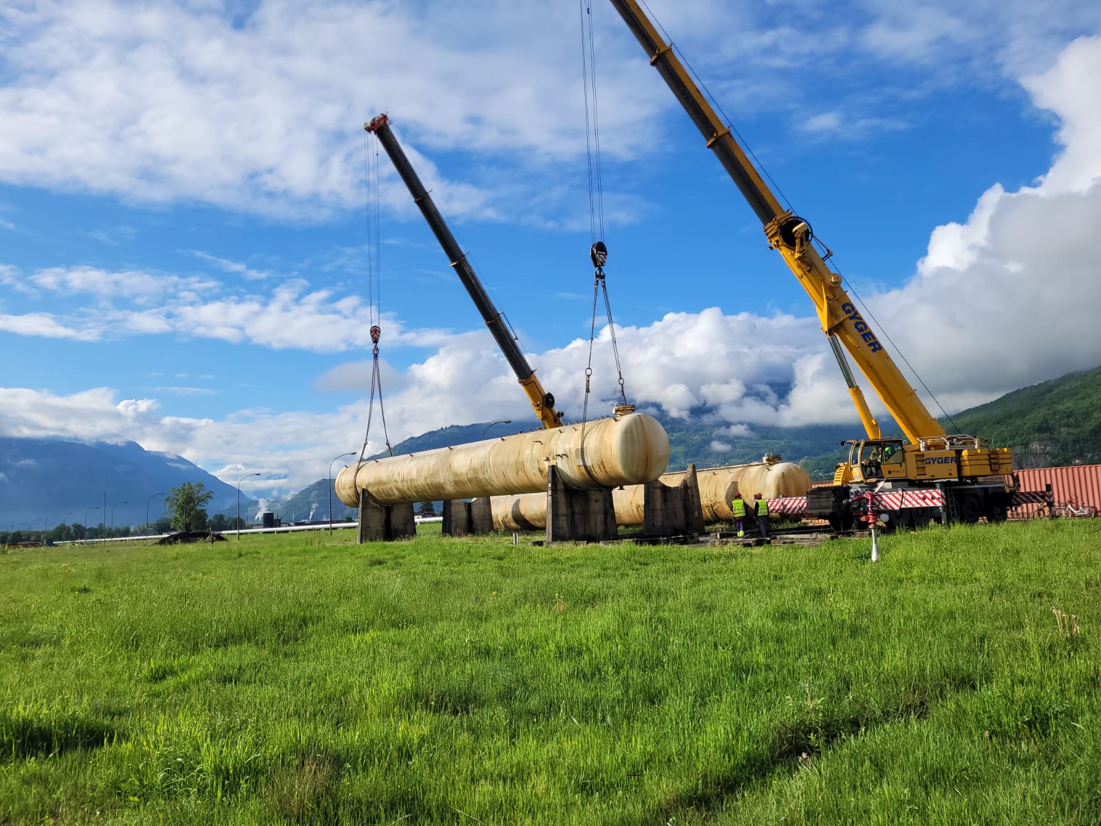 Two mobile cranes lifting a horizontal vessel